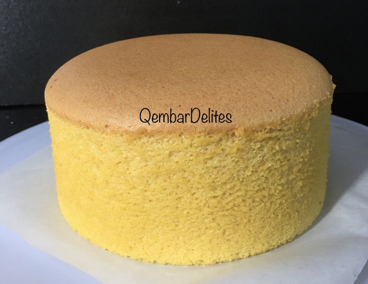 a yellow cake sitting on top of a white plate with the words gendar delites written on it