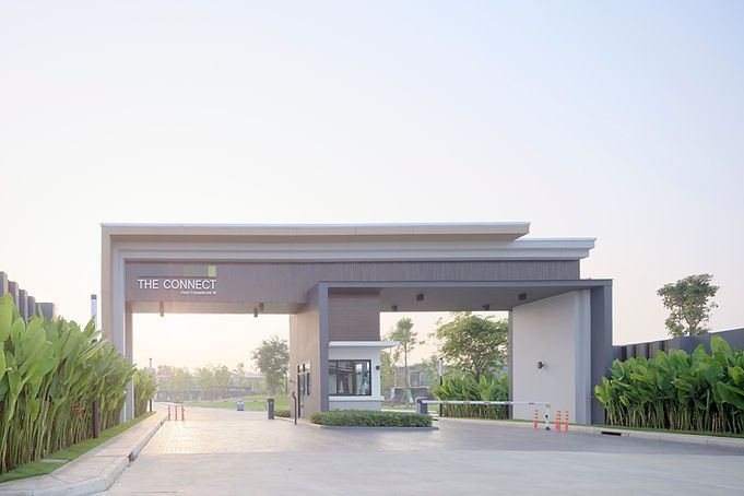 an entrance to a building with trees in the foreground and bushes on either side