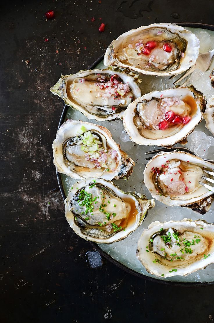 a plate full of oysters with garnishes on them