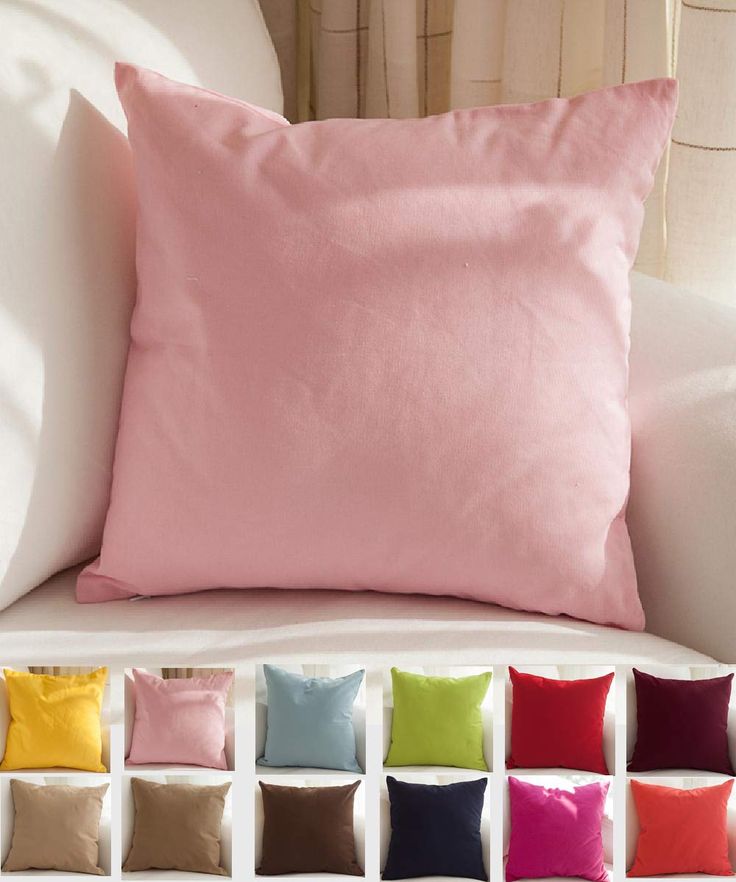 a white couch with many different colored pillows on it's back and side panels