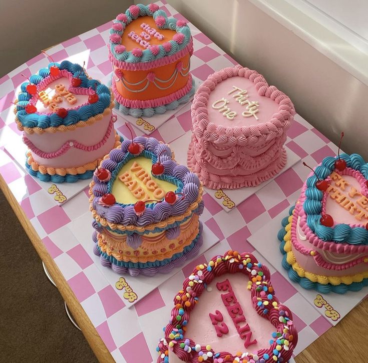 a table topped with lots of cakes covered in frosting