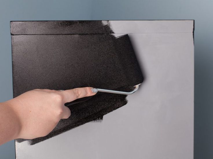 a person using a cell phone on top of a piece of black paper that has been torn off