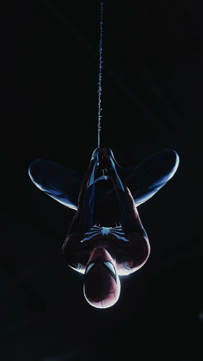 a person hanging upside down in the dark with their feet dangling from a string above them