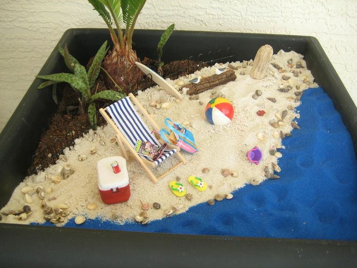 there is a small beach scene made out of sand and shells in a potted planter