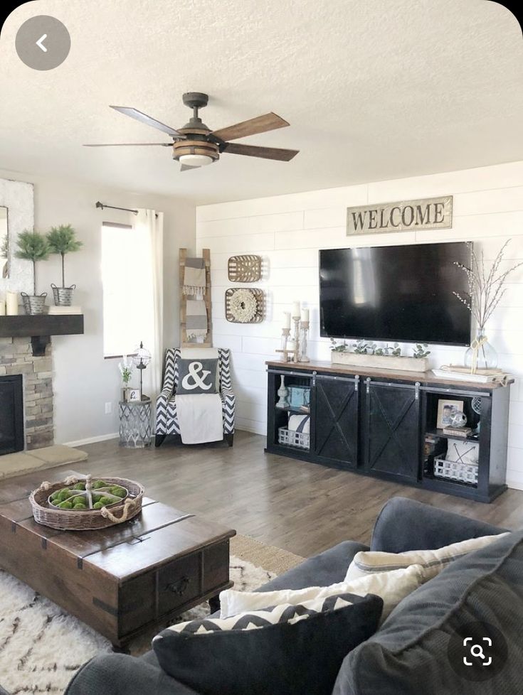 a living room filled with furniture and a flat screen tv on top of a fireplace