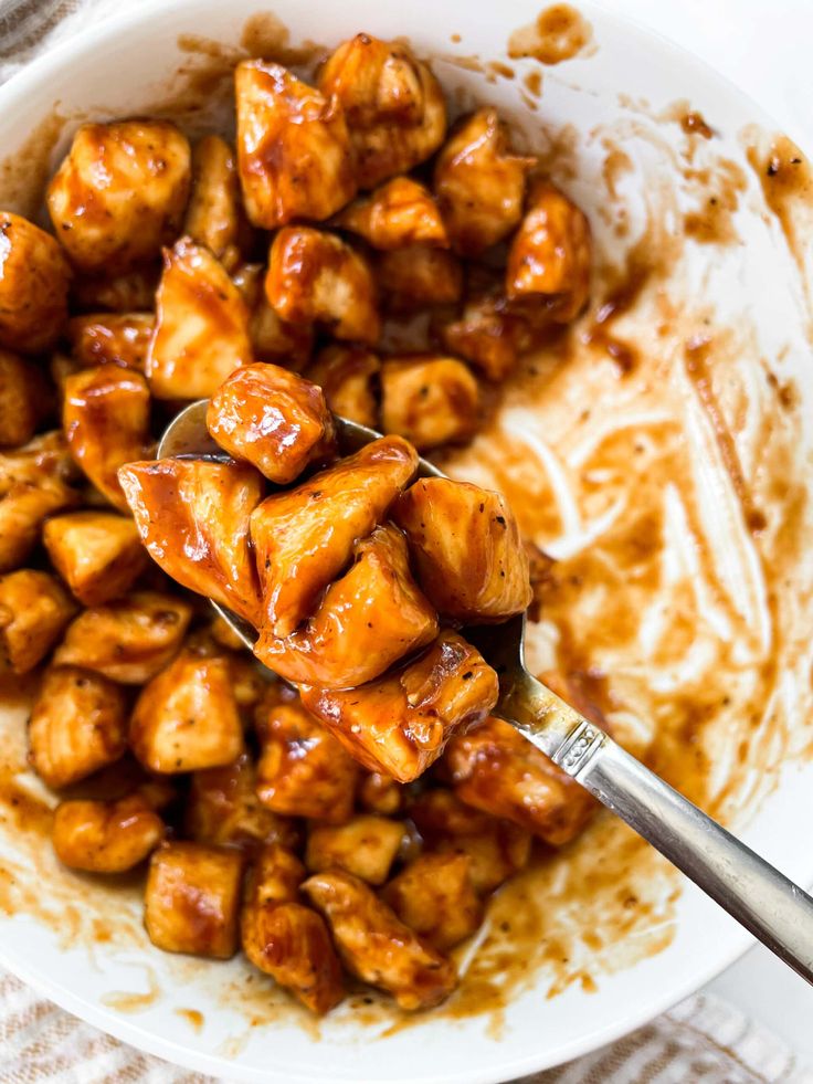 a white bowl filled with meat and sauce