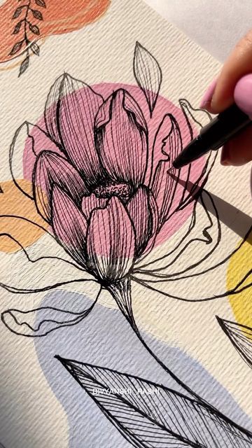 a person is drawing flowers on a piece of paper