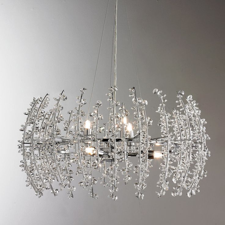 a chandelier hanging from the ceiling in a room with grey walls and flooring