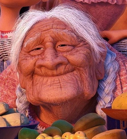 an old woman with bananas and other fruit in front of her, smiling at the camera