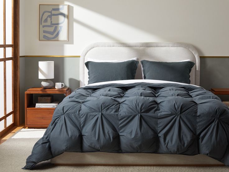 a bed with blue comforters and pillows in a bedroom