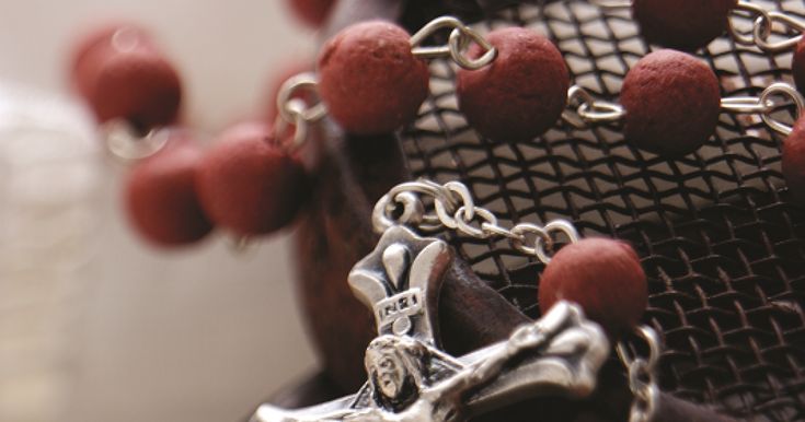 a rosary with red beads and a crucifix on it