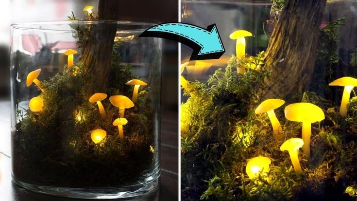 a glass vase filled with yellow mushrooms and moss covered ground next to a tree trunk