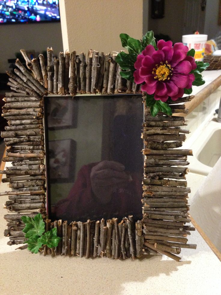 a photo frame made out of sticks and flowers