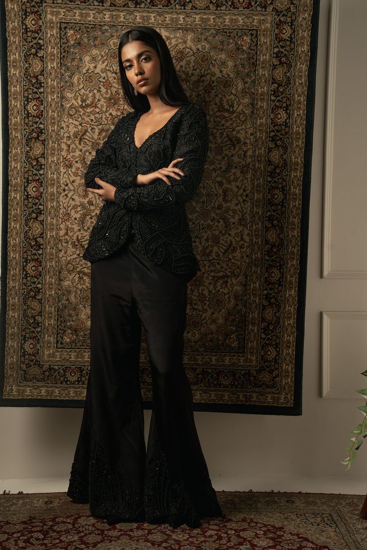 This decadent black pant set embodies unparalleled craftsmanship, showcasing meticulous attention to detail. The top, crafted from luxurious Organza, features intricate bead embroidery that adds an element of sophistication and allure. Paired with silk pants adorned with beautiful embroidery, the ensemble exudes opulence and elegance. Each stitch is a testament to exquisite artistry, making this ensemble a standout choice for any special occasion or formal event.From Jigar & Nikita's Summer Roma Traditional Silk Sets For Evening, Traditional Silk Evening Sets, Elegant Pant Set With Resham Embroidery And Long Sleeve, Elegant Black Palazzo Set For Reception, Elegant Pant Set With Intricate Embroidery For Party, Elegant Party Pant Set With Intricate Embroidery, Traditional Embroidered Pant Set For Party, Traditional Silk Pant Set For Formal Occasions, Traditional Long Sleeve Pant Set For Formal Events