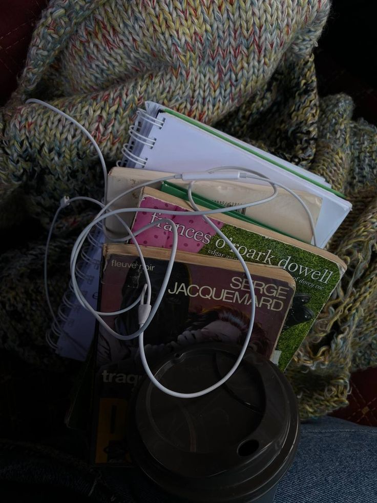 there are many books and headphones on the lap of someone's lap,