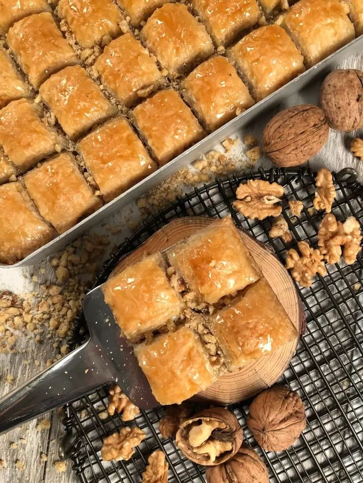 nuts and bread on a cooling rack next to a tray with squares of doughnuts