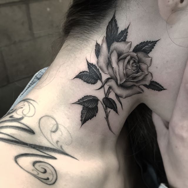 a woman with a rose tattoo on her neck