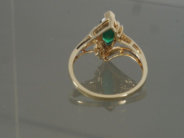 This is a gorgeous bypass ring crafted from 14k yellow gold that features one synthetic marquise chrome diopside accented with two tiny round faceted diamonds on each side. This ring would make a great engagement, promise, anniversary, or right-hand ring. This ring will be shipped in a brand new gift box. RING SIZE: 7.0 (Sizable by your local jeweler) Metal: 14k yellow gold (Verified by acid test) Gemstone: 1 Marquise Synthetic Chrome Diopside (approx. 10.0mm x 5.0mm) & 4 round faceted diamo Yellow Gold Emerald Jewelry With Marquise Cut, Marquise Cut Emerald Jewelry In Yellow Gold, Green Multi-stone Marquise Jewelry, Formal Green Marquise Jewelry, Fine Jewelry With Marquise Cut May Birthstone, Green Marquise 14k Gold Jewelry, Green Marquise Ring With Diamond Accents, Green Marquise Rings With Diamond Accents, 14k Gold Marquise Cut Emerald Ring