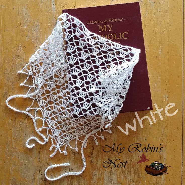 a crocheted doily on top of a book that is laying on the floor