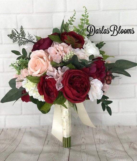 a bridal bouquet with red, pink and white flowers