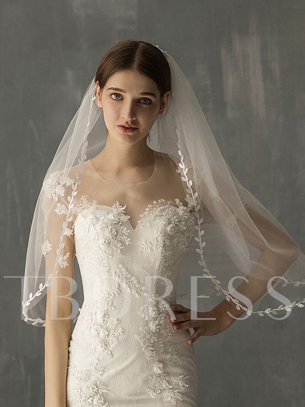 a woman in a wedding dress with a veil on her head