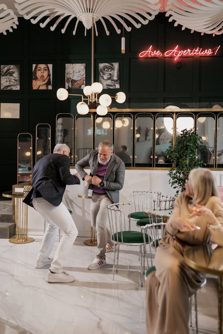 two men are dancing in the middle of a room with people sitting around tables and chairs