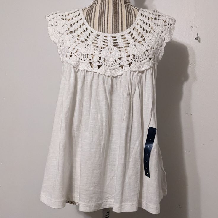 This Was Modeled On A Small Mannequin. This Cute White Cotton Top Is In A Shorter Length, Not A Crop, But The Back Is A Little Longer. Sleeveless With A Crochet Piece That Is The Yolk And Shoulders, Front And Back. Under The Arms The Fabric Flares Out Into A Curved Hem, Giving It A Swingy Look. Pit To Pit Is 23", From Shoulder To Front Edge Is 24 1/2", But It Varies Since It Is A Curved Hem. Lightweight, Cool And Perfect For Summer, Casual Or Dressy, This Top Is Perfect For Both. New With The Br Casual Summer Cotton Lace Tops, White Sleeveless Cotton Lace Top, White Cotton Lace Sleeveless Top, Casual Cotton Lace Top For Summer, Sleeveless Cotton Lace Top With Crochet Trim, Spring Cotton Lace Sleeveless Top, Spring Sleeveless Cotton Lace Top, Sleeveless Cotton Lace Top For Spring, White Cotton Crochet Lace Top