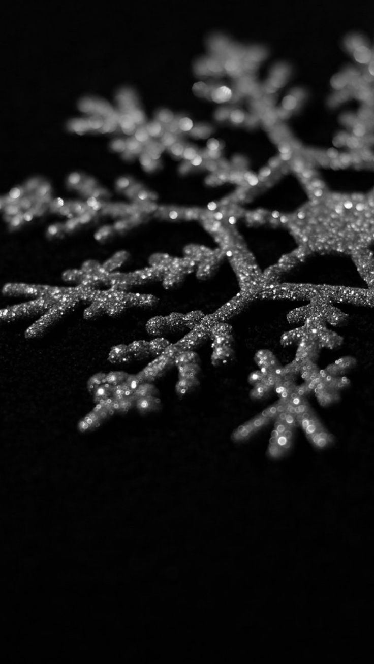 a snowflake is shown in black and white, with some water droplets on it