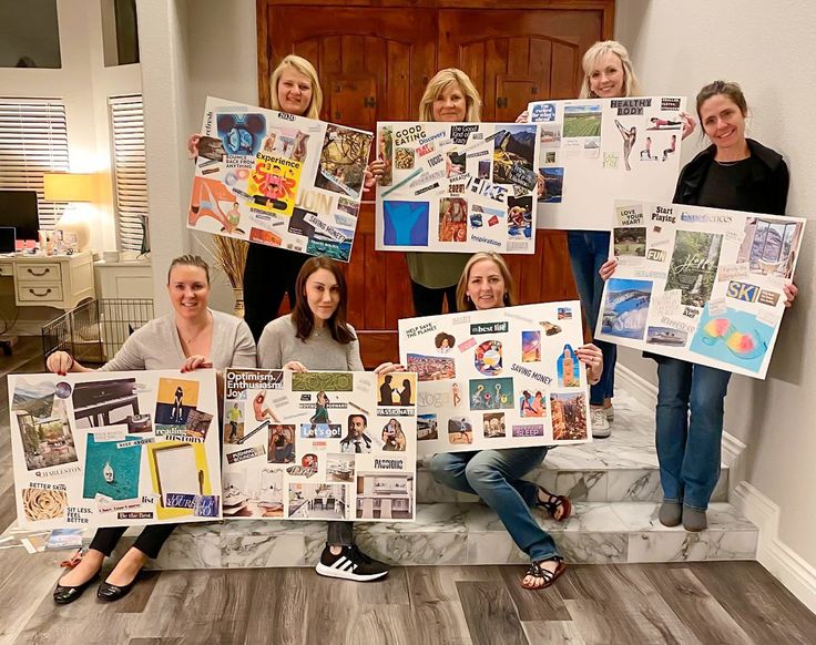 four women holding up pictures and posing for the camera