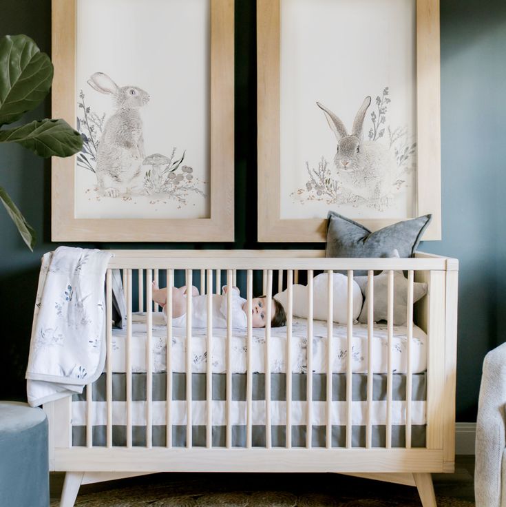 a baby crib with two framed pictures above it