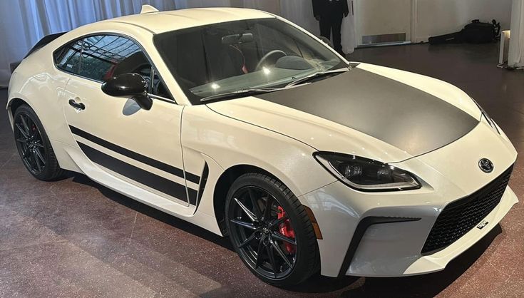 a white sports car parked in a showroom