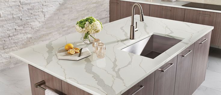 a modern kitchen with marble counter tops and stainless steel appliances, along with white walls