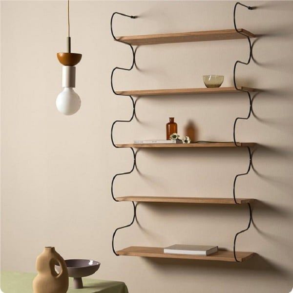 three wooden shelves on the wall in a room with a vase and lamp hanging from it