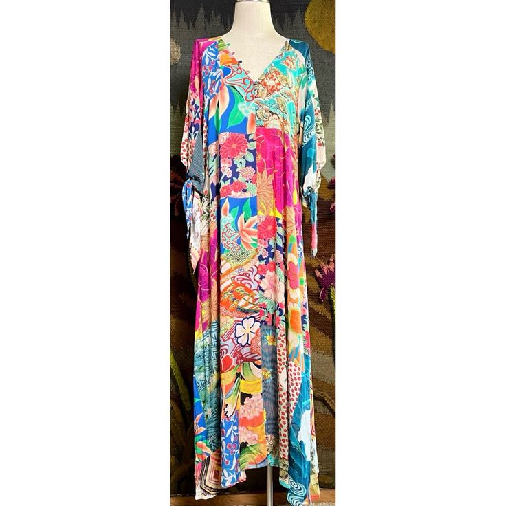 New With Tags Size Small This Gorgeous Maxi Dress By Johnny Was Has A Breezy Bohemian Look. The Long Dress Has A Floral & Mosaic Patchwork Pattern. It Has Three Quarter Sleeves That Have Romantic Ties. This Dress Has A Flattering V-Neck With Buttons Down The Bodice. It Has A Tiered Loose Dropwaist. The Beautiful Dress Is Unlined & Does Not Come With A Slip. It Has Pockets! Measurements Laying Flat: Length 56 1/4” Bust 18 1/4” Waist 18.5” Hips 20” Vibrant Multicolor V-neck Dress, Pink Vibrant Print Dress For Beach Cover-up, Colorful Floral Print Beach Cover-up Dress, Multicolor Vibrant Print Beachwear Dress, Vibrant Tropical Print Multicolor Dress, Vibrant Multicolor Tropical Print Dress, Vibrant Floral Print Maxi Dress, Vibrant Multicolor Maxi Dress Beach Cover-up, Colorful Printed Beachwear Dresses