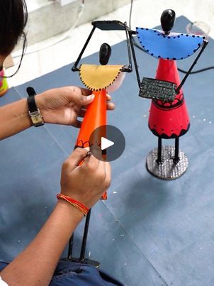 a woman is working on some colorful sculptures