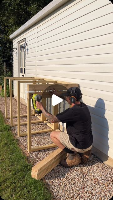 a man is working on the side of a house with some tools in his hand