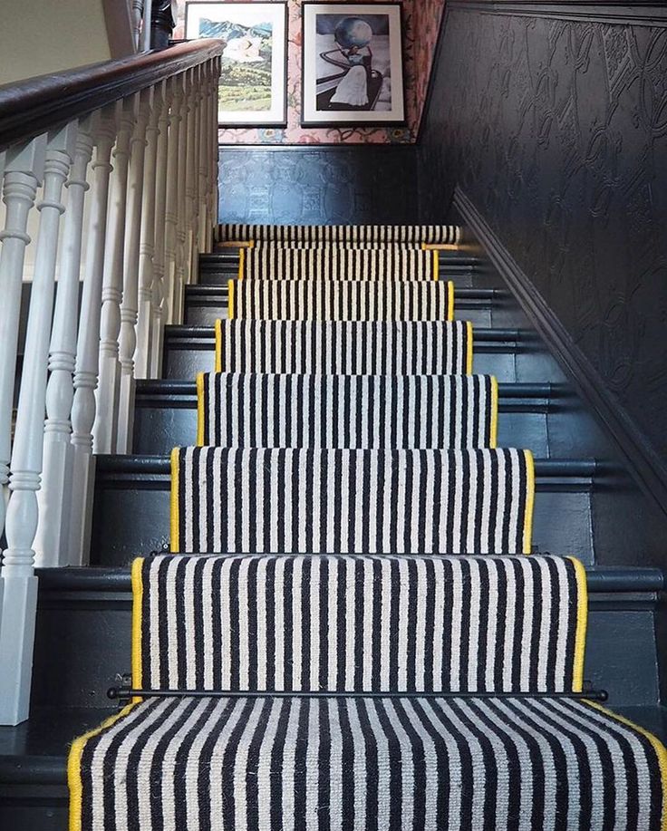 the stairs are painted black and white with yellow trim, along with striped rugs