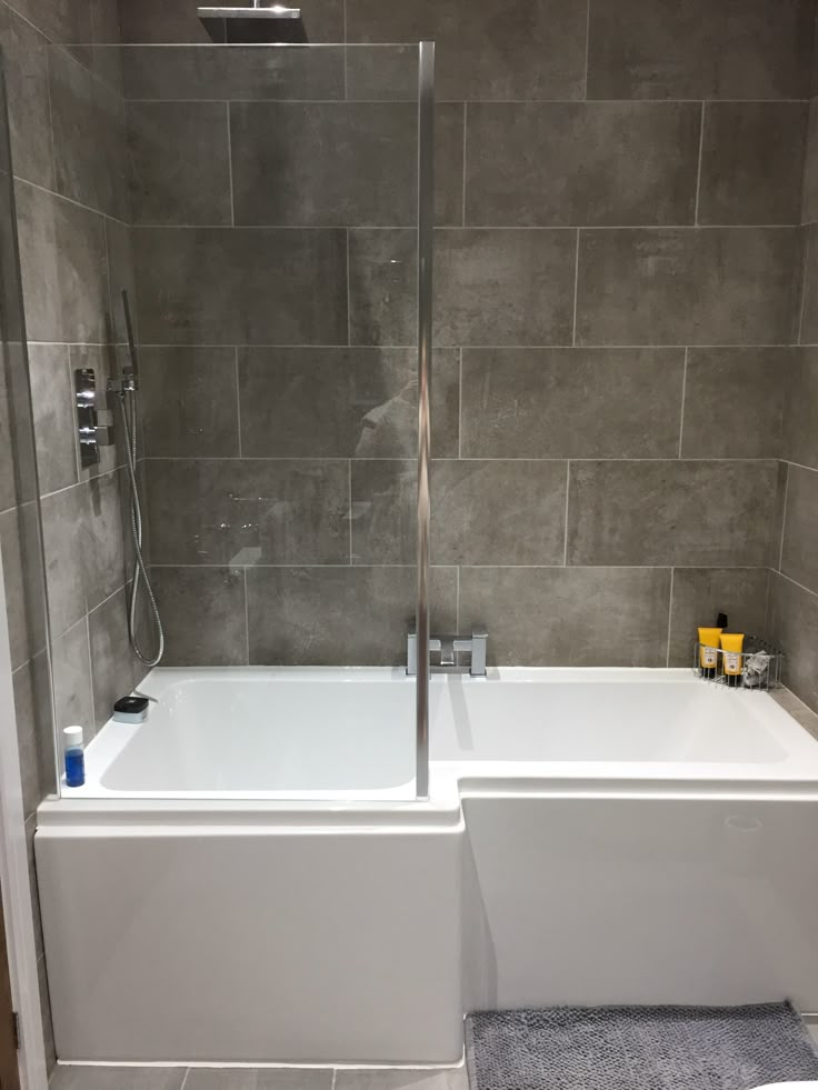 a white bath tub sitting next to a walk in shower