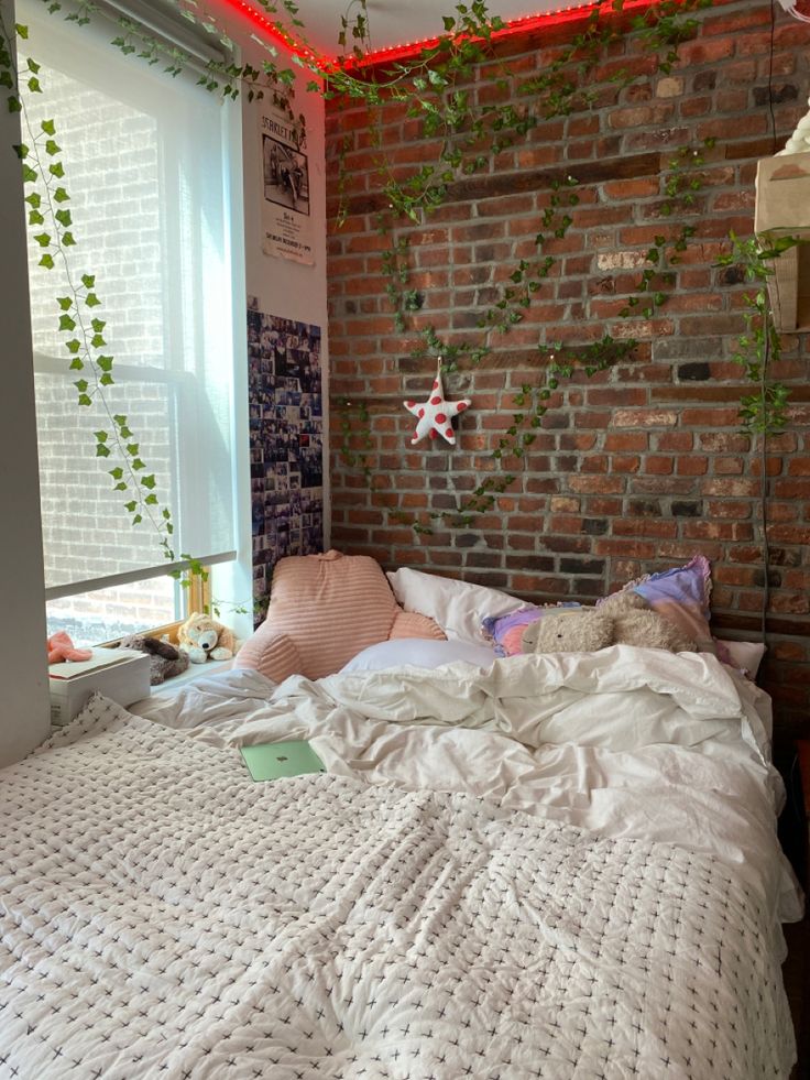 an unmade bed in front of a brick wall with ivy growing up the side