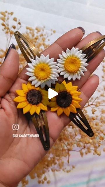 a person is holding three sunflowers in their hand and they are made out of hair pins