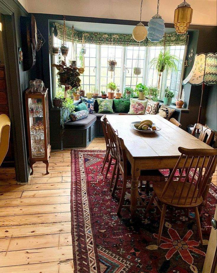 a dining room table with chairs and a rug on the floor in front of it