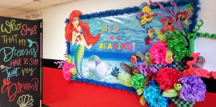 there is a bulletin board with mermaids and other decorations on it in the classroom