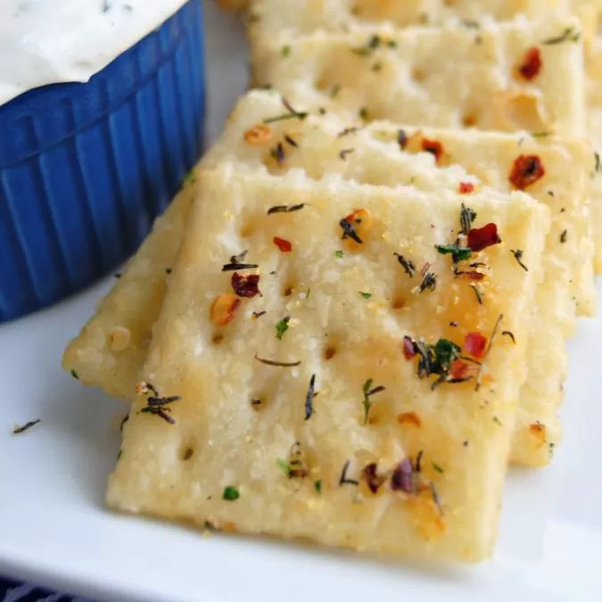 crackers on a white plate with a blue container in the backgroung