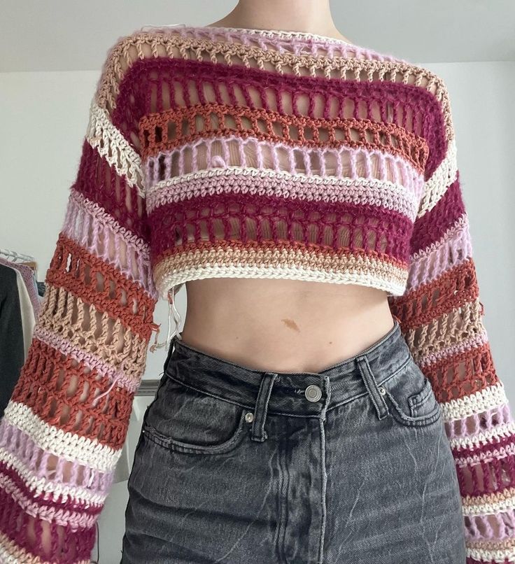 a close up of a person wearing jeans and a cropped top with crochet