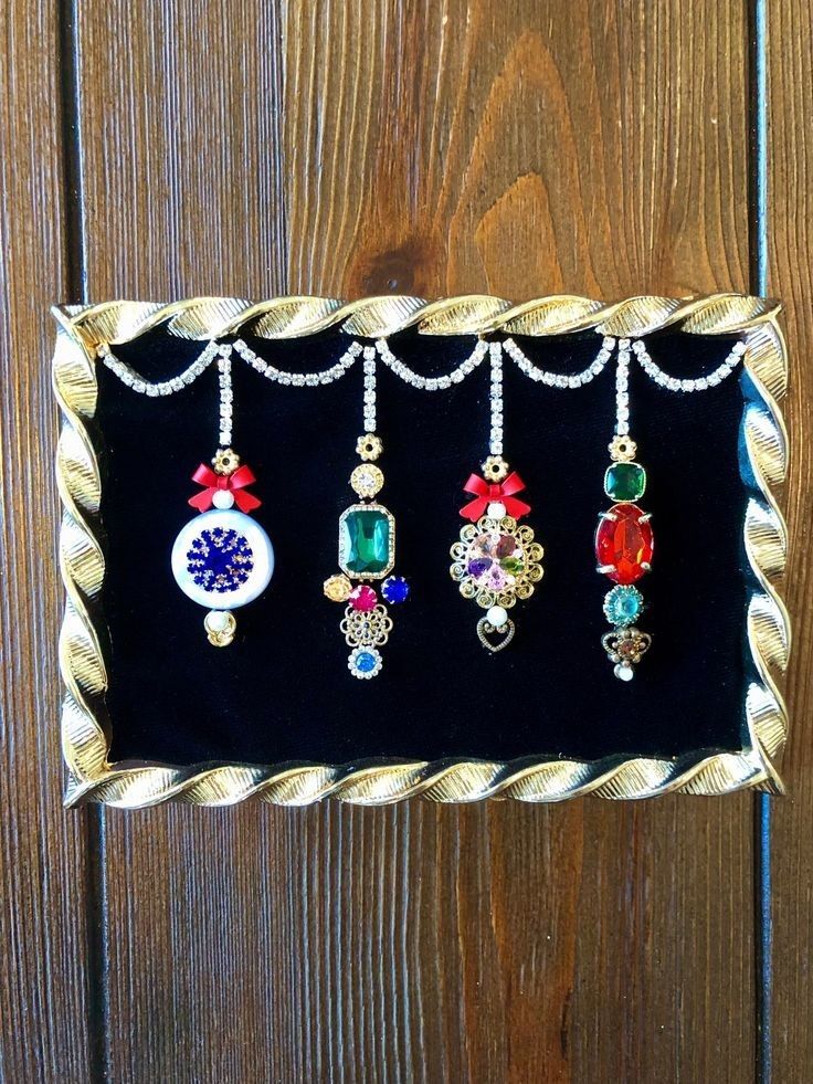 five different colored necklaces are hanging on a black velvet display case against a wooden wall