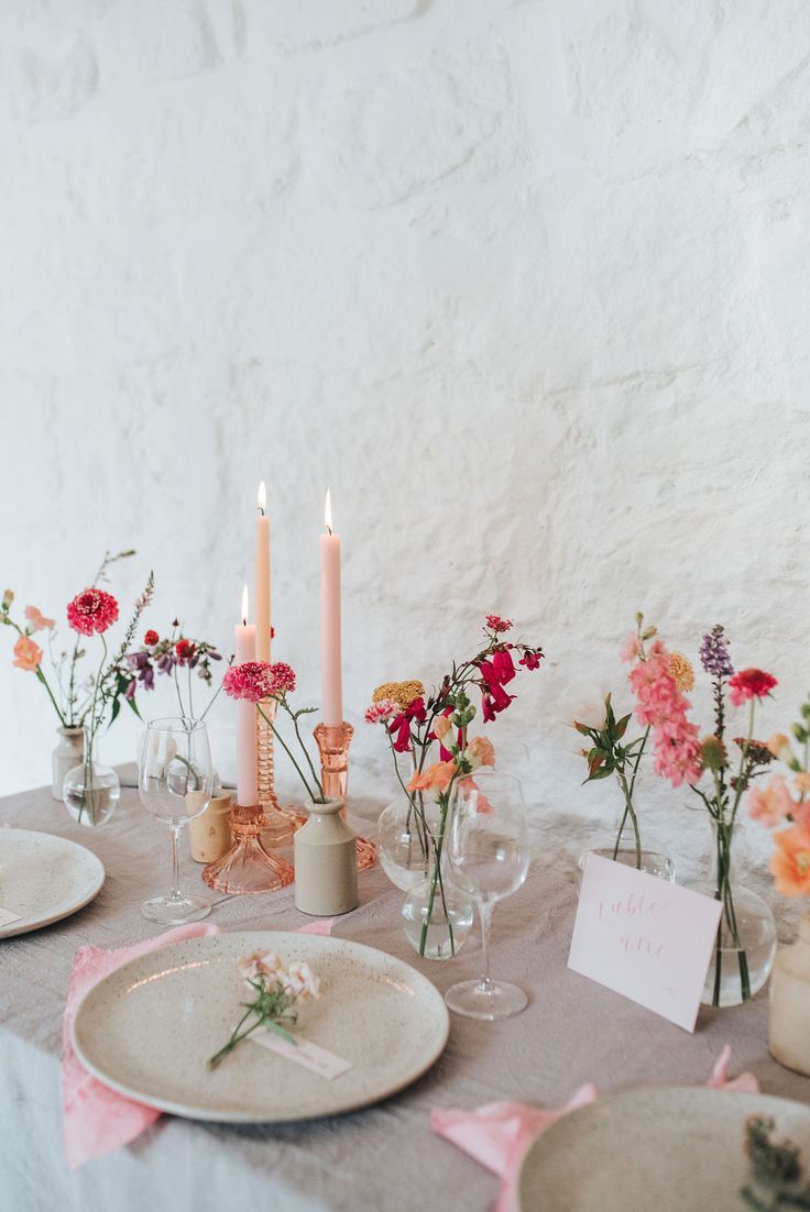 the table is set with flowers and candles