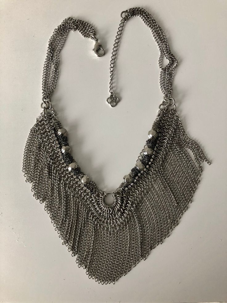 Beautiful well made chain metal fringe necklace silver colour. I bought this years ago from a company who sells different small jewelry designers. Hand made. Very excellent workmanship. Has little white crystal details.  Great for casual wear with jeans or wear it with a dress. Can also be worn for those who are punk, gothic metal or hipsters fashion . Silver Rhinestone Necklace With Adjustable Chain, Trendy Fringe Metal Jewelry, Trendy Silver Fringe Jewelry, Chic Silver Fringe Jewelry, Chic Silver Jewelry With Fringe, Festival Silver Fringe Jewelry, Festival Fringe Metal Jewelry, Bohemian Silver Beaded Chain Necklace, Silver Beads Metal Chain Necklace For Parties