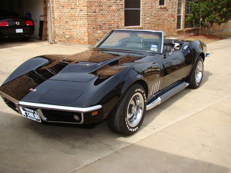 a black sports car parked in front of a brick building