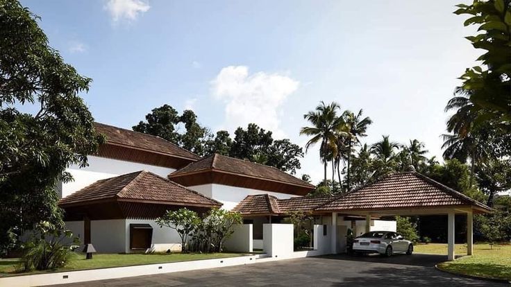 a white car parked in front of a building with two pavilions on each side