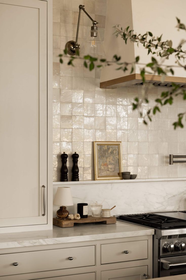 a kitchen with white cabinets and tile backsplash